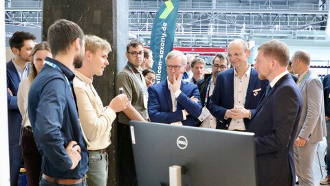 Sachsens Ministerpräsident Michael Kretschmer (r.) informierte sich bei Dr. Moritz Herzog und den Clustersprechern Prof. Gerhard Fettweis und Prof. Jochen Hampe (v.l.) an den Silicon Saxony Days.