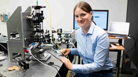 Frau Dr. Katrin Philipp sitzt rechts im Bild vor ihrem Mikroskop