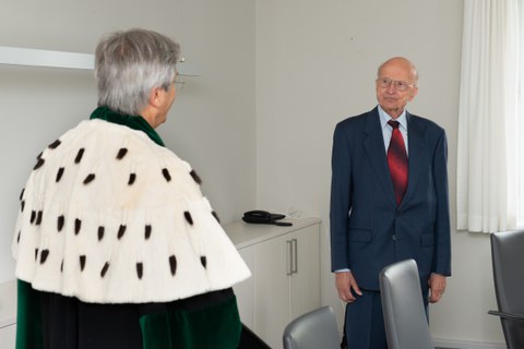 Der Rektor, rechts im Bild mit Talar, übergibt die Ehrenmedaille der TUD an Prof. Hacker, der rechts im Bild steht.