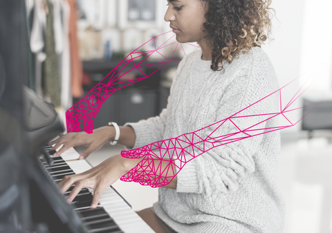 Eine junge Frau spielt Klavier, als rosa Grafik sind ihr künstliche Arme eingezeichnet worden.