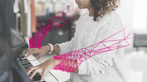 Eine junge Frau spielt Klavier, als rosa Grafik sind ihr künstliche Arme eingezeichnet worden.