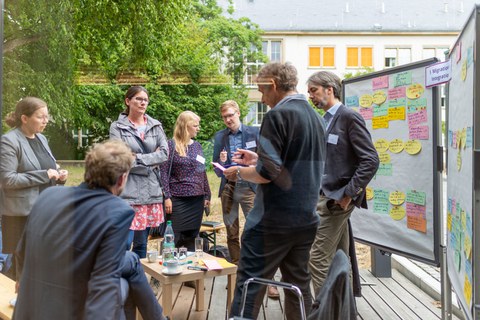 Menschen diksutieren im Grünen