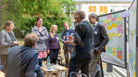 Menschen diksutieren im Grünen