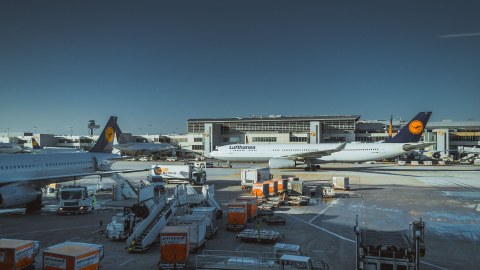 Flughafenszene, verschiedene Lufthansa-Maschinen, Fahrzeuge und Ausrüstung auf dem Rollfeld eines Flughafens