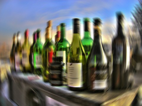 Ein Tisch voll Alkohol-Flaschen, das Bild erscheint verschwommen