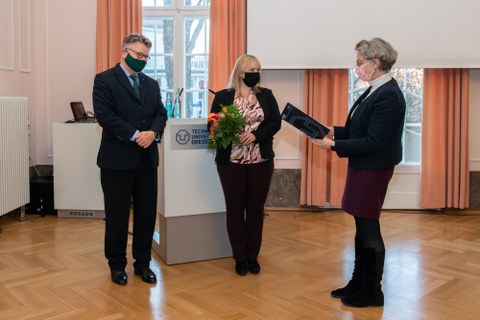 Übergabe einer Urkunde an eine Frau.