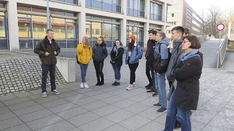 TUD-Student Florian (l.) mit einer der Schülergruppen des Herzberger Philipp-Melanchthon- Gymnasiums nahe dem Hörsaalzentrum an der Bergstraße.