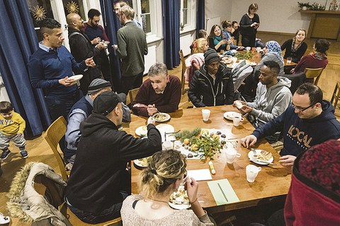 Prof. Michael Kobel (sitzend, M.) mit Asylbewerbern beim Adventsfest »Willkommen in Löbtau« 2019.