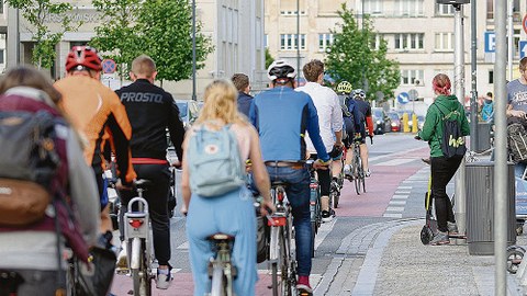 Eine Gruppe Fahrradfahrer fährt auf einem städtischen Radweg.