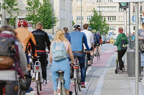 Eine Gruppe Fahrradfahrer fährt auf einem städtischen Radweg.