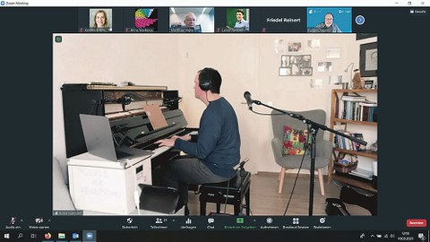 Screenshot des Konzertes, Adrian Zendeh sitzt mit Kopfhörern am Klavier.