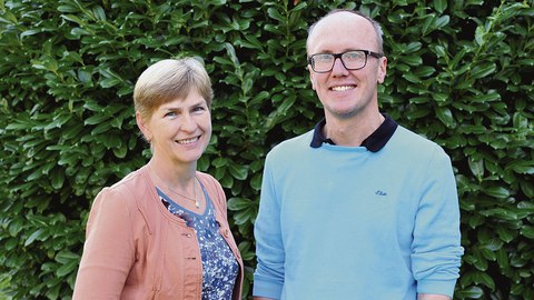 Dr. Monika Diecke und Bernhard Chesneau stehen nebeneinander vor einem grünen Busch.