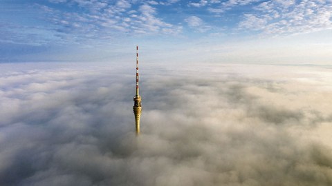 Die Spitze des Fernsehturms ragt aus den Wolken.
