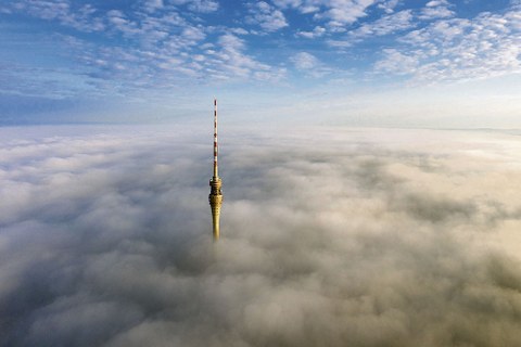 Die Spitze des Fernsehturms ragt aus den Wolken.