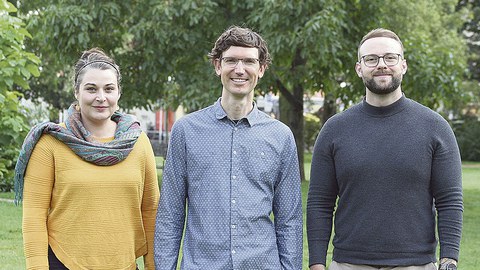 Das Gründungsteam von Open Physio steht auf einer Wiese in einem Park mit Bäumen.