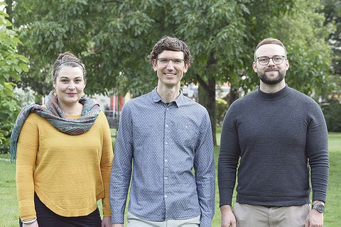 Das Gründungsteam von Open Physio steht auf einer Wiese in einem Park mit Bäumen.