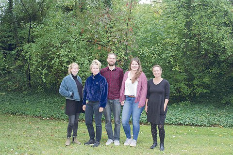 Das ELF-Team steht vor einem grünen Busch auf der Wiese.