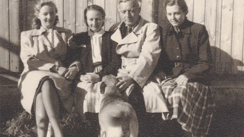 Mutter, Großeltern und Tante der Autorin sitzen nebeneinander auf einer Bank vor einem Haus. Der Hund steht davor. (SW-Foto)
