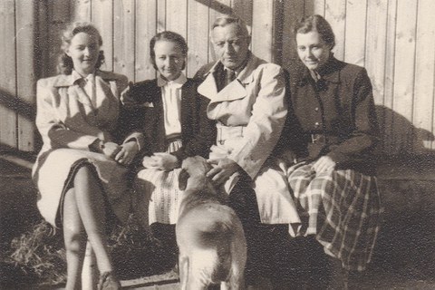 Mutter, Großeltern und Tante der Autorin sitzen nebeneinander auf einer Bank vor einem Haus. Der Hund steht davor. (SW-Foto)