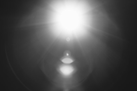 Das Foto zeigt die schwarz-weiß Aufnahme eines hellen einfallenden Lichtes. Der Rest des Bildes ist schwarz.