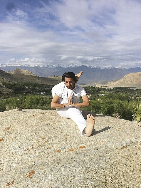 Subit Kumar Mishra auf einem Felsen. Im Hintergrund sind hohe Berge zu sehen.