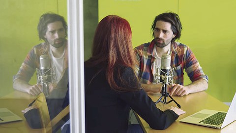 Ein Mann und eine Frau sitzen gegenüber. Sie unterhalten sich.