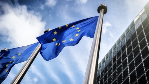 Zwei Flaggen der EU wehen vor einem Gebäude.
