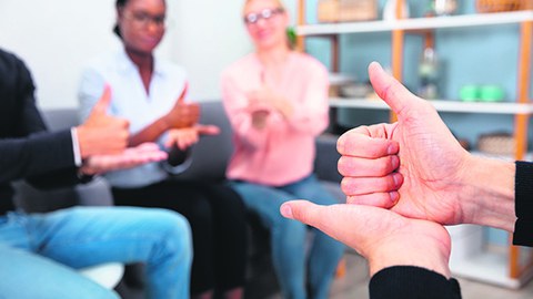 Eine Gruppe Menschen beim Erlernen der Gebärdensprache.