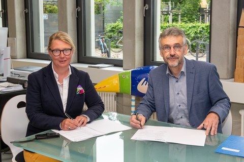 Prof. Michael Kobel, Prorektor Bildung der TU Dresden, und Sandra Gockel, Schulleiterin des Ehrenfried-Walther-von-Tschirnhaus-Gymnasiums, unterzeichnen den gemeinsamen Kooperationsvertrag.