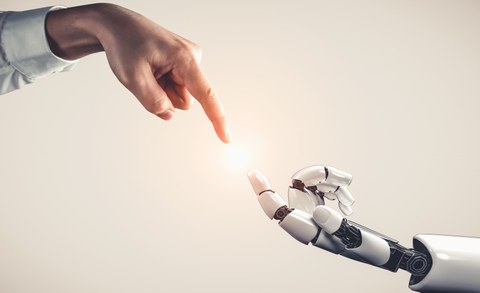 Menschliche Hand und Roboterhand berühren sich fast.