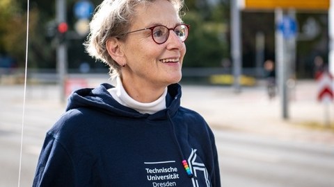 Foto der Rektorin Prof. Ursula M. Staudinger, die einen dunkelblauen Kapuzenpullover trägt und lächelt