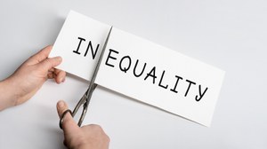 Ein Papierbogen mit der Aufschrift InEquality wird mit einer Schere nach dem In zerschnitten.