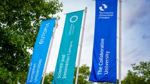 Foto von drei im Wind wehenden Flaggen vor dem Rektoratsgebäude in hellblau, türkis und blau. Darauf steht "eutopia", "DRESDEN concept" und "Technische Universität Dresden".