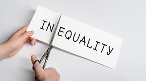 Ein Papierbogen mit der Aufschrift InEquality wird mit einer Schere nach dem In zerschnitten.