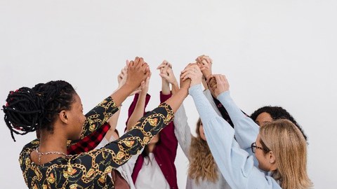 verschiedene Frauen stehen im Kreis - die Hände treffen sich in der Mitte