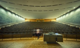 Hörsaal im Hörsaalzentrum der TU Dresden. Im Vordergrund steht das Sprecherpult. Im Hintergrund befinden sich die Bankreihen.