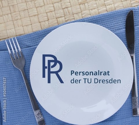 Teller auf einemblauen Tuch auf einem geflochtenen Platzdeckchen mit Messer und Gabel und PR-Logo
