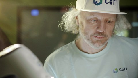 Portraitfoto von Prof. Fitzek, der ein weißes Basecap mit dem Logo von CeTI trägt und konzentriert nach unten schaut.