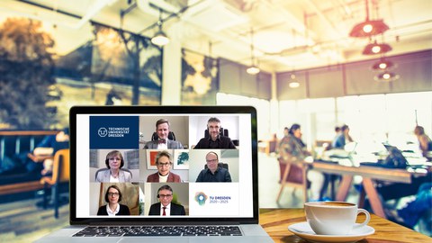 unfolded laptop on table in a cafe, on the screen of which the members of the Extended University Executive Board can be seen in a video conference