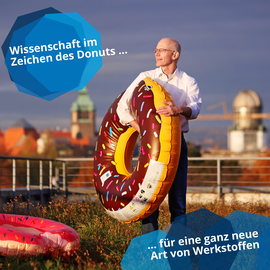 Foto von Prof. Vojta mit einem aufblasbarem Donut in der Hand