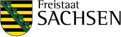 Sächsisches Staatswappen mit Schriftzug "Freistaat Sachsen" rechts. Wappen zeigt im neunmal von Schwarz und Gelb horizontal geteilten Feld einen schrägrechten grünen Rautenkranz.