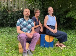 Photo of Louis Kohaupt, Katharina Schmitt and Lissy Flechsig sitting on three Claiming Campus stools.