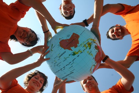 Tutors from the International Office are holding a globe together