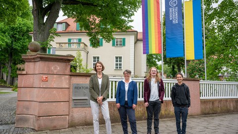 Das Foto zeigt 4 Personen vor dem Rektorat, im Hintergrund sind 3 Flaggen zu sehen, die Progressive Falg, die TU Flagge und die ukrainische Flagge.