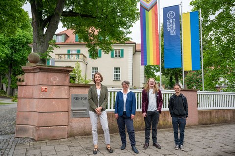 Das Foto zeigt 4 Personen vor dem Rektorat, im Hintergrund sind 3 Flaggen zu sehen, die Progressive Falg, die TU Flagge und die ukrainische Flagge.