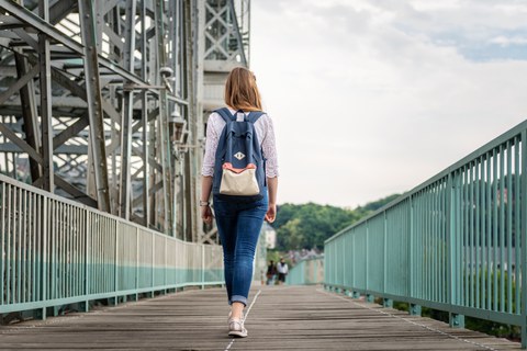 Foto: Eine Studentin läuft über das Blaue Wunder. Wir sehen sie von hinten.