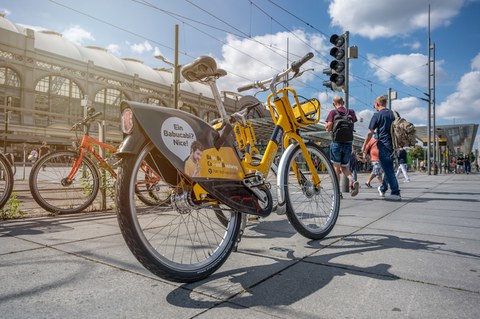 Ein gelbes Fahrrad vor dem Dresdener Hauptbahnhof.