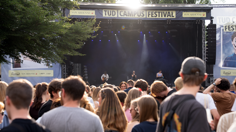 Photo from the campus festival on the campus of TU Dresden. It shows a concert with many visitors.