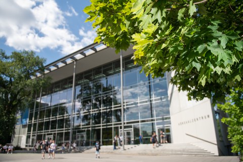 Ein Gebäude mit großer Glasfront und Treppe davor.