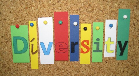 Buchstaben sind an einer Pinnwand befestigt und ergeben das Wort Diversity